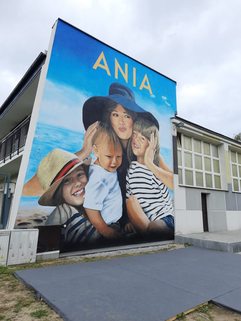 Mural na gdyńskim liceum, który przedstawia Anię Przybylską z dziećmi.